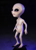 JET Alien prop with almond black eyes standing against dark background