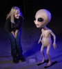Standing alien prop greets person with cute smile and big eyes