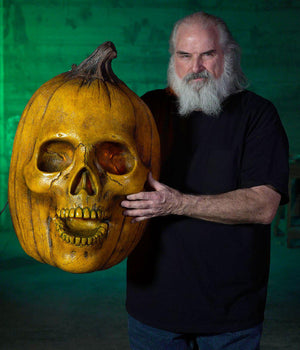 Distortions owner Ed Edmunds holds Giant Blazing Pumpkin wall hanging prop
