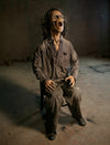 Grim scary haunted house prop sitting in a chair