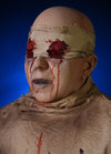 Face close up of ICU Animatronic Prop holds bloody eyeballs and has blue fog behind