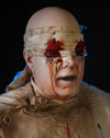 ICU animatronic prop face with bloody bandage around eyes