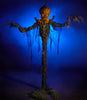 8 Ft tall Pumpkin Stalker Halloween prop decoration by Distortions Unlimited. Giant monster with creepy pumpkin head and long arms and fingers standing in blue fog.